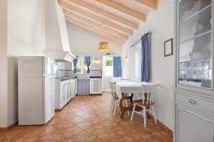 a kitchen with a table and a white refrigerator at Casa Flor de Sal in Moncarapacho