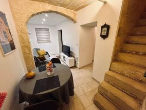 a room with a table and a living room with a staircase at Charming 200 year old cottage with yard in Żabbar