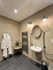 W łazience znajduje się umywalka i lustro. w obiekcie West Highland Hotel w mieście Mallaig