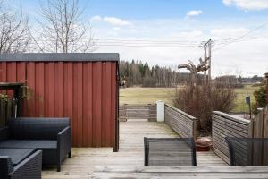 a patio with a red fence and a red building at Sparkling modern house in Kista - close to city in Stockholm