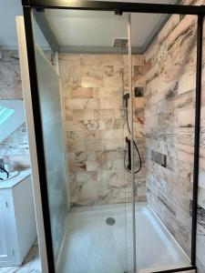 een badkamer met een douche en een stenen muur bij Centre-ville f3 tout confort in Beaumont-sur-Oise