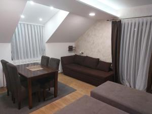a living room with a table and a couch at Apartments Vila Djurdja in Kopaonik