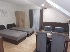Sala de estar con 2 camas y mesa en Apartments Vila Djurdja en Kopaonik