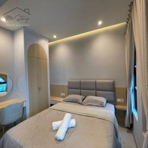 a bedroom with a bed with two white towels on it at MiStay 4-5PAX Luxury Suite Apartments in Kota Kinabalu
