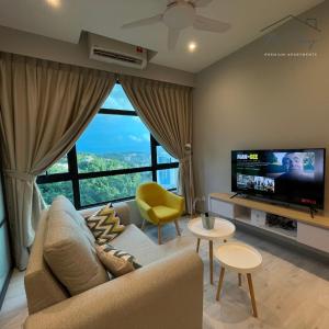 sala de estar con sofá y TV de pantalla plana en MiStay 4-5PAX Luxury Suite Apartments en Kota Kinabalu