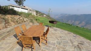 Stay at the Winemaker في Ervedosa do Douro: طاولة وكراسي خشبية على فناء حجري