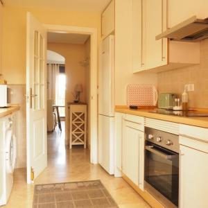 a kitchen with white cabinets and a stove top oven at Duplex Penthouse in Estepona- Mountain and Sea views in Estepona