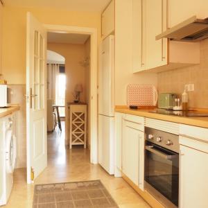kuchnia z białymi szafkami i kuchenką w obiekcie Duplex Penthouse in Estepona- Mountain and Sea views w mieście Estepona