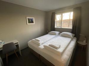 a bedroom with a large bed with a window at Guesthouse Bitra B&B in Selfoss