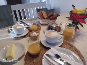 una mesa cubierta con tazas de café y productos para el desayuno en Sole e Ventu (70 qm), en San-Giovanni-di-Moriani