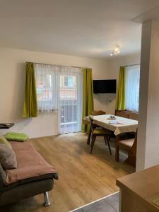 a living room with a table and a dining room at Ferienwohnung Wetterstein in Lermoos