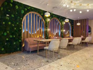 a restaurant with tables and chairs and a green wall at Trabzon Gloria Suite Hotel in Trabzon