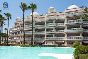 - un grand bâtiment avec une piscine en face dans l'établissement Residencial Casablanca Casa Azahar, à Alcossebre