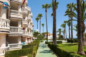 une passerelle devant un bâtiment planté de palmiers dans l'établissement Residencial Casablanca Casa Azahar, à Alcossebre