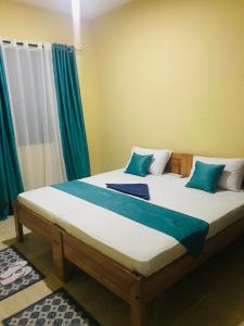 a bedroom with a large bed with green curtains at Hyven's Apartments in Mtwapa