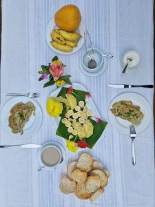 una mesa blanca con platos de comida. en World's View Wild Camping Salaszoi, Principe Island en Santo António