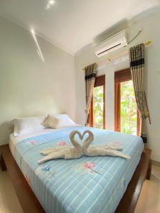 ein Bett mit zwei Schwänen aus Handtüchern in der Unterkunft Rengganis Homestay in Yogyakarta