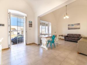 - un salon avec une table, des chaises et un canapé dans l'établissement Spacious holiday home in Marina di Mancaversa with terrace, à Marina di Mancaversa
