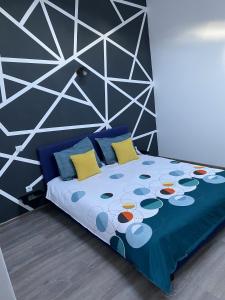 a bedroom with a bed with a blue comforter and yellow pillows at Alvi Apartment Poiana Brasov in Poiana Brasov