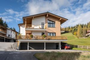 dom z balkonem i samochód zaparkowany przed budynkiem w obiekcie JARA APARTMENT- Ramsau am Dachstein w mieście Ramsau am Dachstein