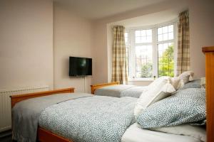 a bedroom with two beds and a tv on the wall at Hidden Gem Canal Facing Retreat with lovely walks in Hopwas