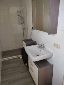 een badkamer met een wastafel, een spiegel en een toilet bij Ferienwohnung ländlich und in Seenähe in Schörfling
