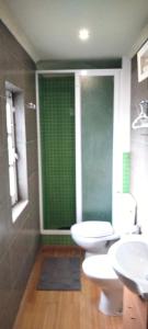 een badkamer met 2 toiletten en een groen raam bij Casinha de chocolate in Outeiro