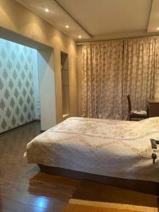 um quarto com uma cama grande e uma janela em Comfortable 2 rooms apt in Centre of Tashkent city em Tashkent