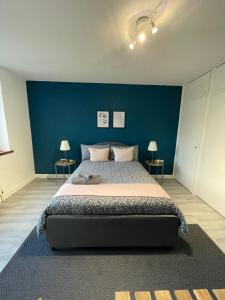 a bedroom with a large bed with a blue wall at Willesden Green ROOMS in London