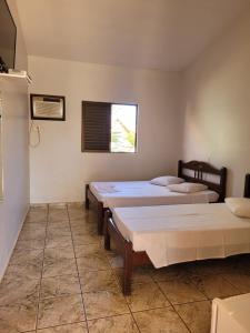 een kamer met 2 bedden en een raam bij Pousada Sol Nascente in Paraopeba