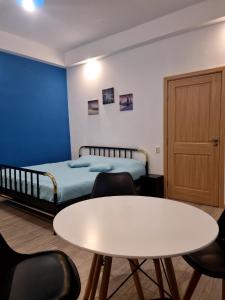 um quarto com uma cama, uma mesa e cadeiras em EVU Long Street em Braşov