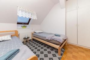 1 dormitorio con 2 camas y ventana en Apartma Lea, en Slovenj Gradec