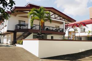 a building with a palm tree in front of it at AMALFI718 HOTEL in Lipa