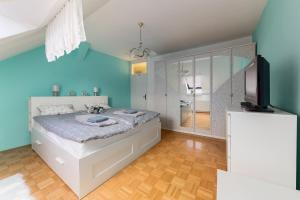 a blue bedroom with a bed and a television at Apartma Lea in Slovenj Gradec