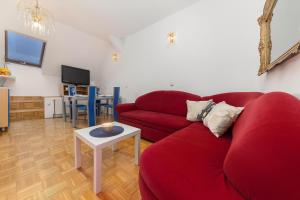 a living room with a red couch and a table at Apartma Lea in Slovenj Gradec