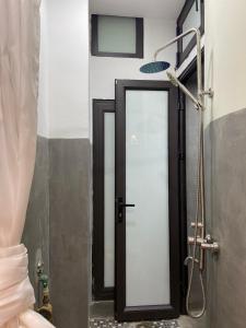 La salle de bains est pourvue d'une douche avec une porte en verre. dans l'établissement the second home of yours, à Hanoï