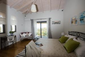 a bedroom with a bed and a table and a chair at Villa Sania in Kassiopi