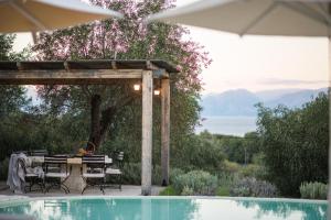 um pátio com uma mesa e cadeiras ao lado de uma piscina em Villa Sania em Kassiopi