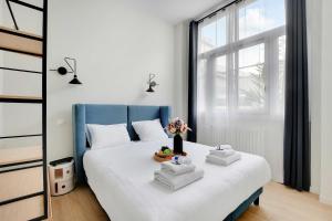 ein Schlafzimmer mit einem blauen und weißen Bett mit Handtüchern darauf in der Unterkunft Luxurious Apartement - Near the Eiffel Tower Champs de Mars in Paris