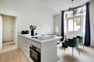 Una cocina blanca con un fregadero y una mesa. en Luxurious apartment - 2BR-6P - Javel-Tour Eiffel, en París
