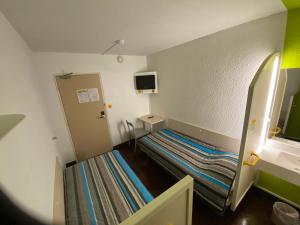 a small room with a bunk bed and a tv at Hotel Class'Eco Carcassonne in Carcassonne