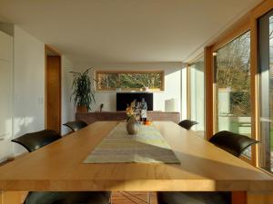 a dining room with a wooden table and chairs at Casa Farnach in Bildstein