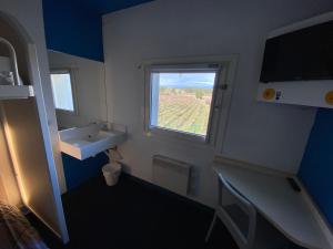 a bathroom with a sink and a window at Hotel Class'Eco Carcassonne in Carcassonne
