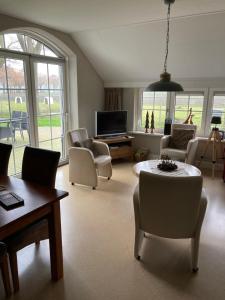 uma sala de estar com um sofá e uma mesa em bed en breakfast westerwolde em Sellingen