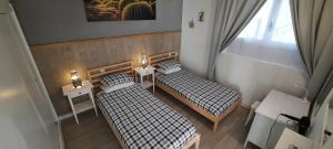 two beds in a room with two tables and a window at Lanzarote-Beach-Apartment, Las Cucharas Beach, Costa Teguise -- 1 MINUTE WALK FROM MAIN SQUARE, 35 METERS FROM BEACH in Costa Teguise +51 photos