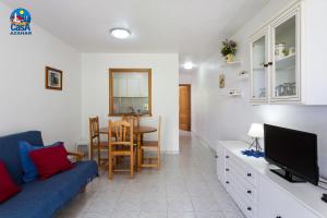 a living room with a blue couch and a tv at Residencial Al Andalus Casa Azahar in Alcossebre