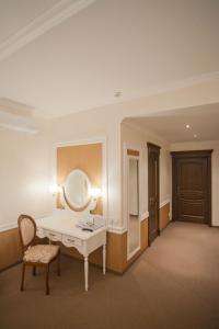 キーウにあるOrly Park-Hotelの洗面化粧台、鏡、椅子が備わる客室です。
