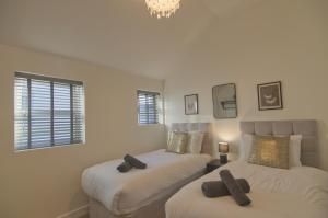 a bedroom with two beds with black crosses on them at Harbour Heights, Luxury Coastal Apartment in The English Riviera, close to the Shops, Bars, Restaurants, Marina and Beaches in Torquay