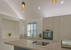a kitchen with white cabinets and a counter top at Harbour Heights, Luxury Coastal Apartment in The English Riviera, close to the Shops, Bars, Restaurants, Marina and Beaches in Torquay