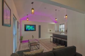 a living room with purple lighting and a kitchen at Harbour Heights, Luxury Coastal Apartment in The English Riviera, close to the Shops, Bars, Restaurants, Marina and Beaches in Torquay